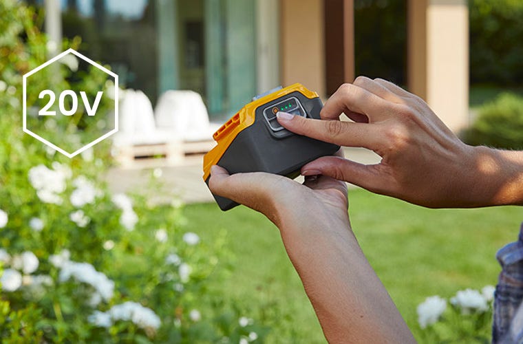 Macro van twee handen die een batterij vasthouden