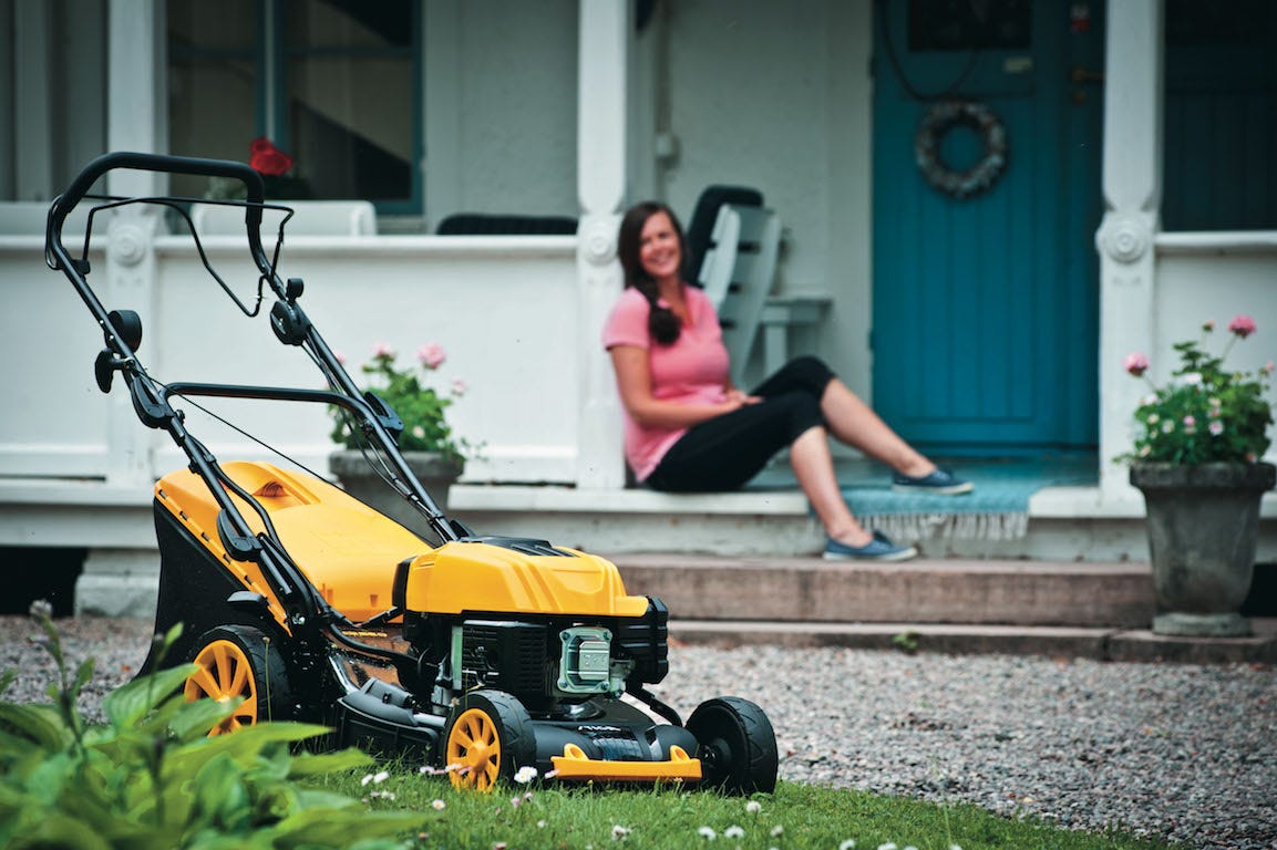 tondeuse à gazon dans un jardin à côté d'un porche