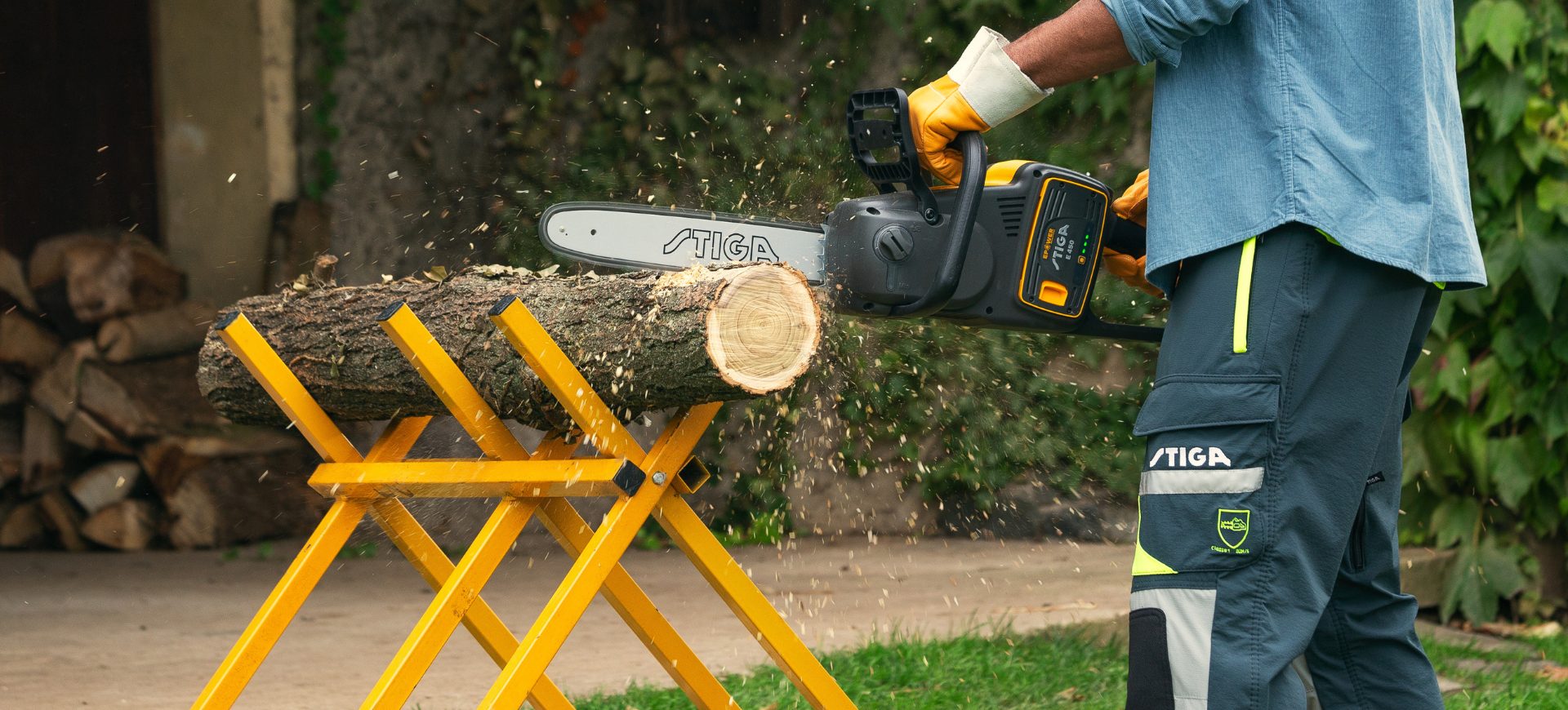 man cutting tree log with STIGA chainsaw