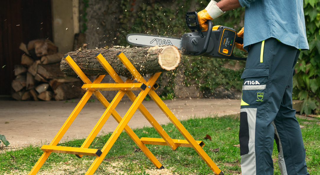 man cutting tree log with STIGA chainsaw