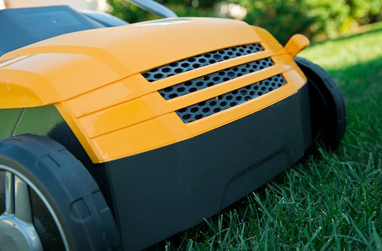 Front detail of yellow STIGA scarifier on lawn